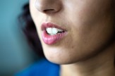 An up-close photo of a woman&#039;s mouth as she is speaking.