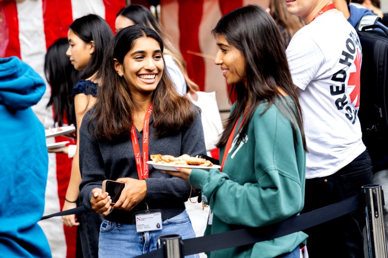 Two female students shown chatting at Husky Fest on the London campus.