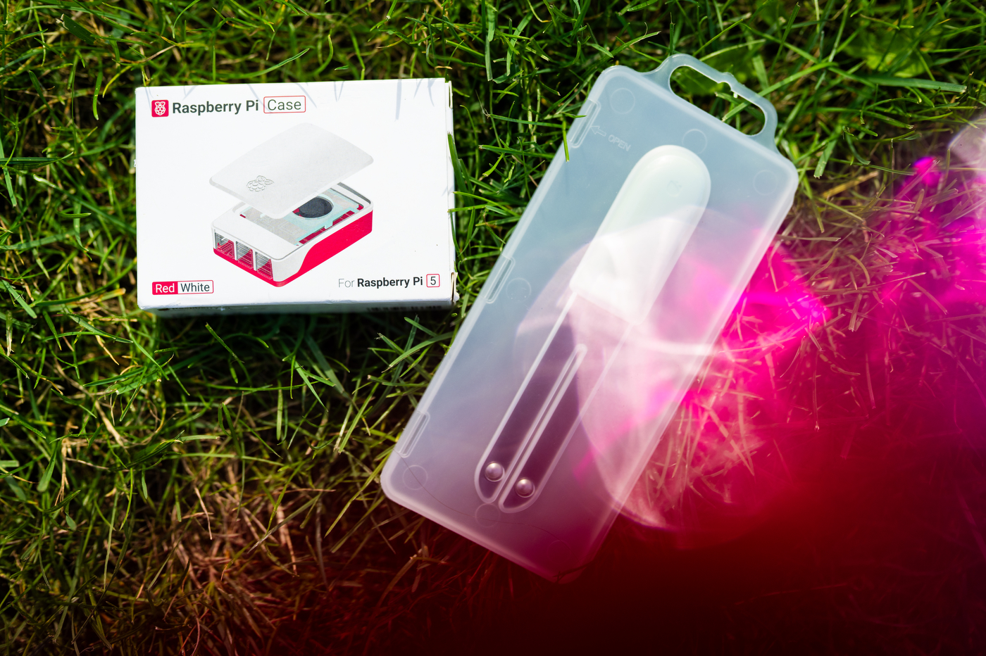 The smart irrigation device pictured in a white plastic case against the grass.