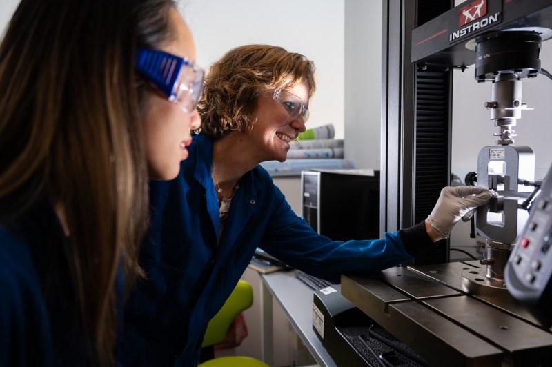 Two people wearing safety goggles work in a lab.