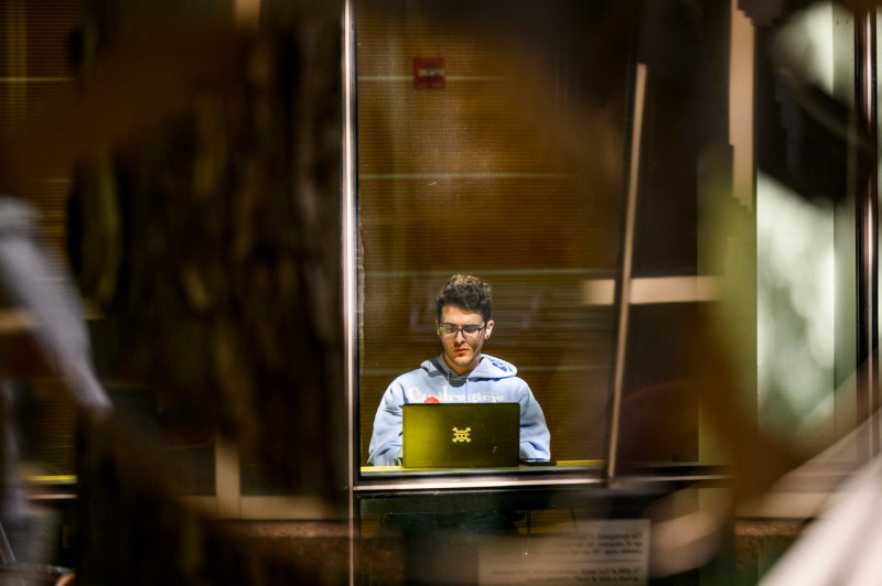 A person works on a laptop at a table.