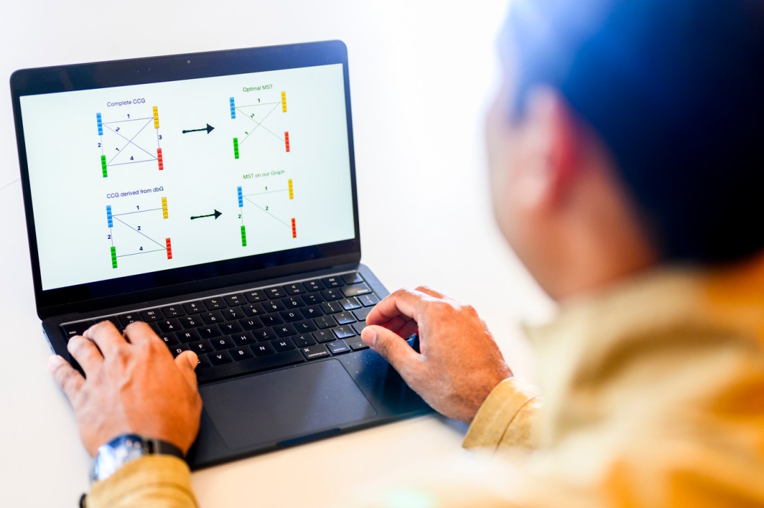 Prashant Pandey using a laptop to analyze genomic data sequences. 