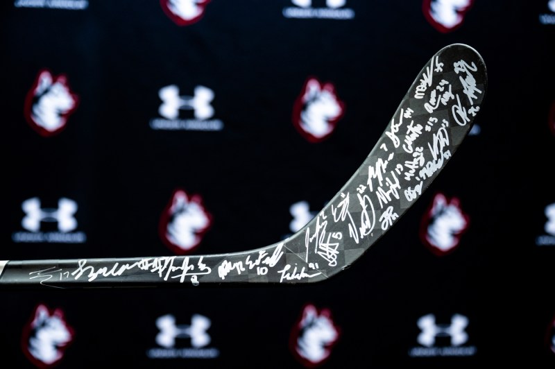 A close-up photo of a hockey stick, which is signed by players of the Northeastern hockey team.
