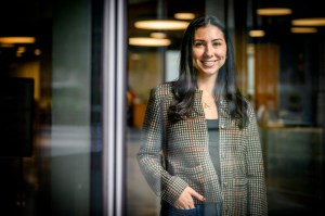 Portrait of Sarah Martins seen through a glass window.
