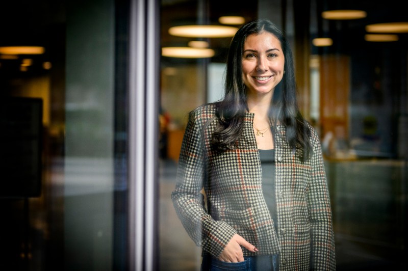 Portrait of Sarah Martins seen through a glass window.