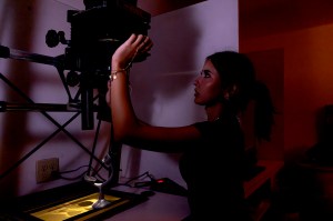 A student adjusts equipment in a darkroom at the Print Media Labs on the Oakland campus.