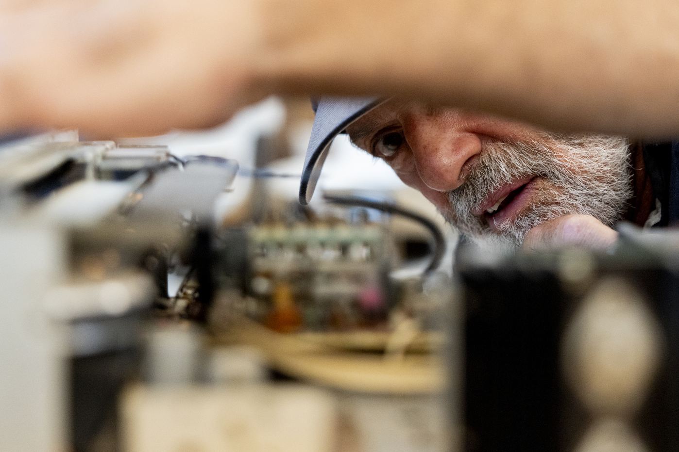 A close-up photo of a person repairing a stereo amp.