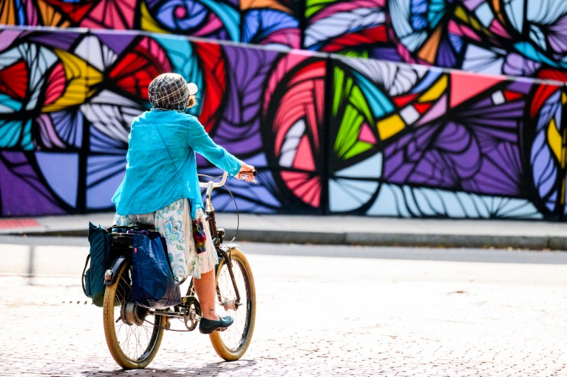 A person rides on a bicycle on campus.