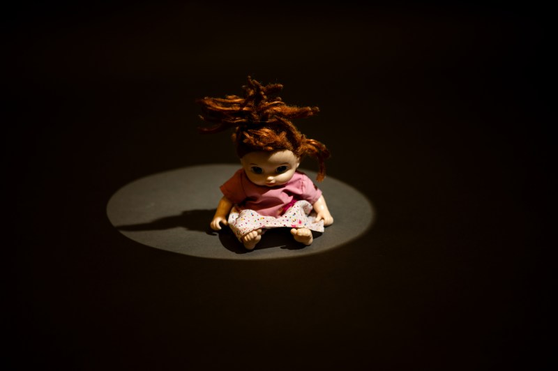 A close-up photo of a creepy doll on a pedestal.