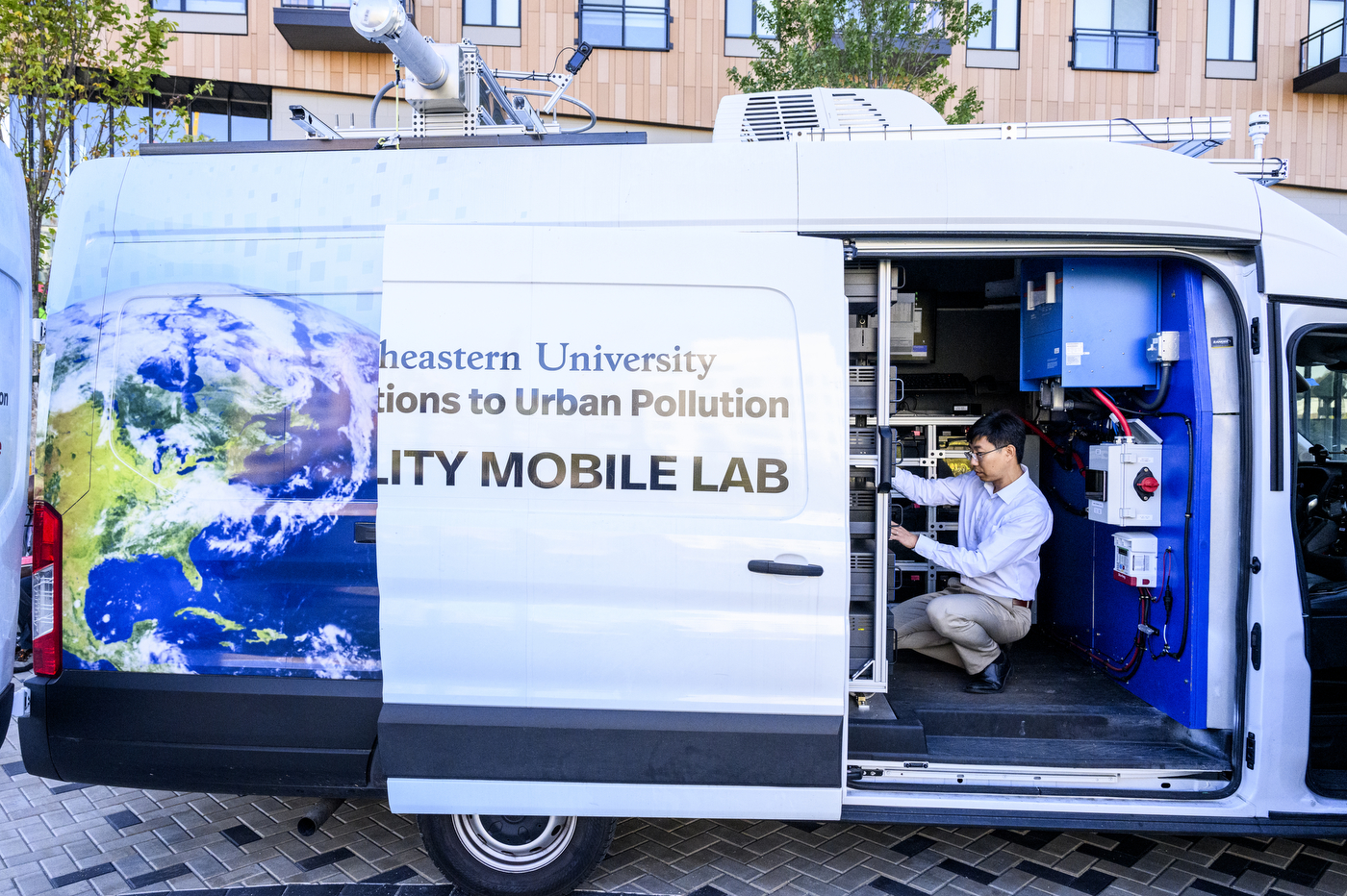 Researcher operates equipment inside Northeastern University’s Air Quality Mobile Lab van, which is parked in Allston, Massachusetts.