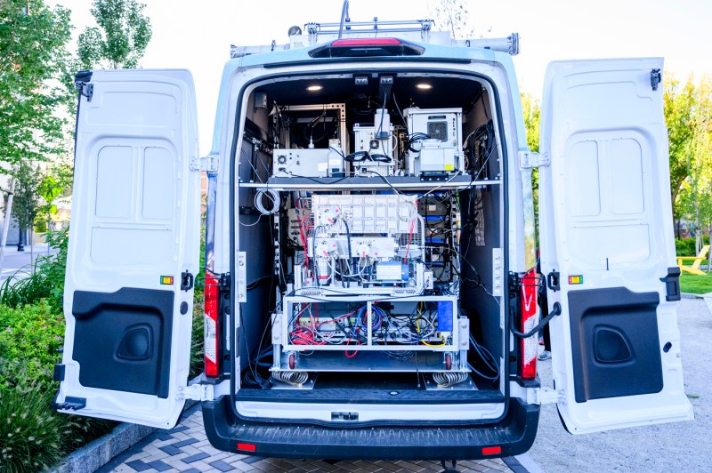 The back doors to a mobile van are open, displaying the technology that the van is equipped with.