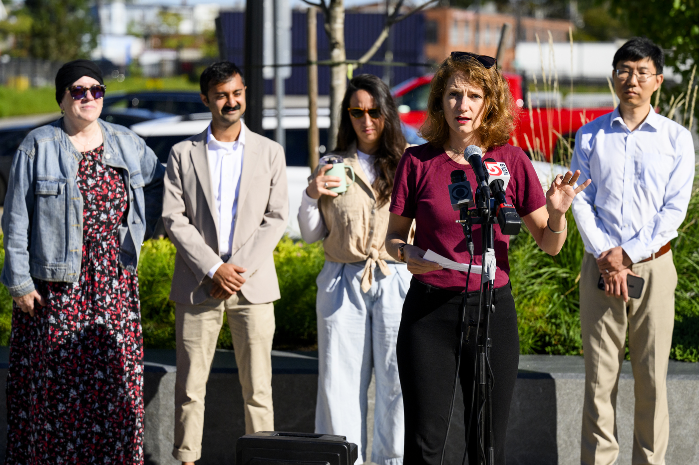 Speaker at a podium with microphones addresses attendees at the City of Boston Air Grant event in Allston, Massachusetts.