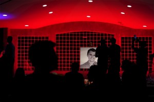 A memorial to conservative activist Charlie Kirk in a dark red-lit room.