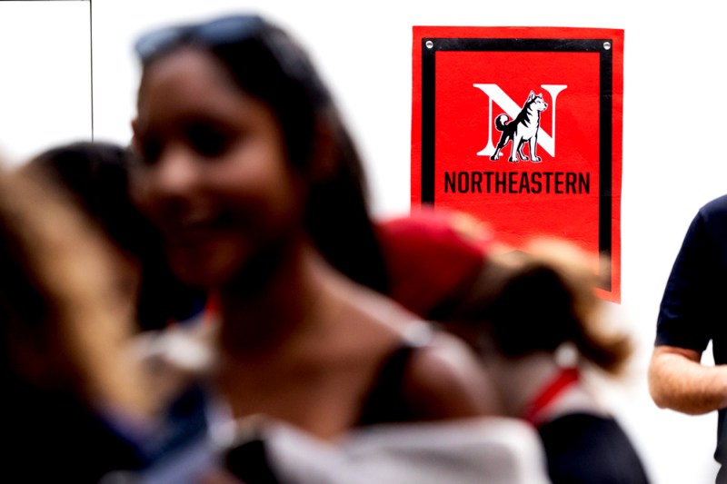 A Northeastern banner hangs on a wall. 
