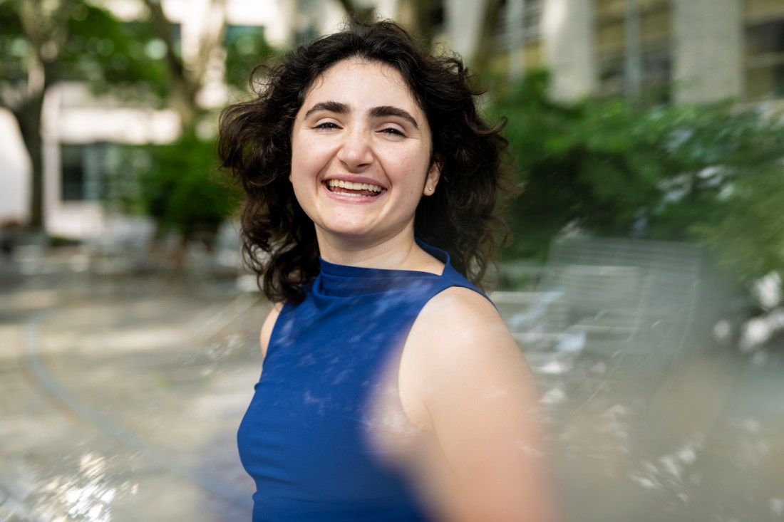 Chloe Wein, a biomedical engineering student, depicted in a blue dress and smiling.