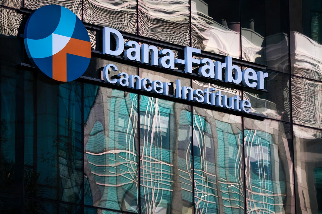 The Dana-Farber Cancer Institute sign is shown on the glass exterior of the institute’s building in Boston.