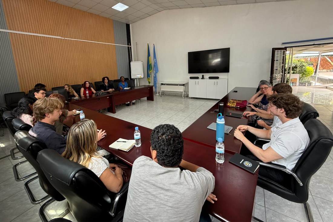 Students from the Rwanda Dialogue sit around a large rectangular table.