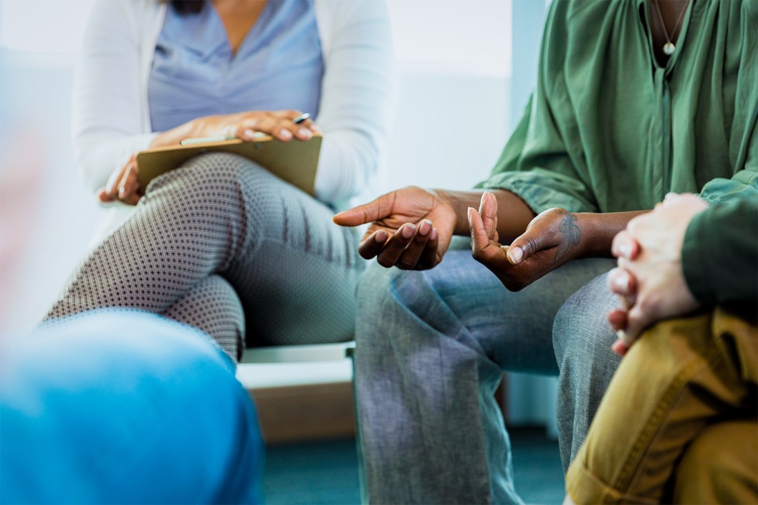 A photo with the focus on the hands of several faceless individuals gathered around in a circle.