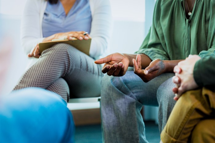 A photo with the focus on the hands of several faceless individuals gathered around in a circle.