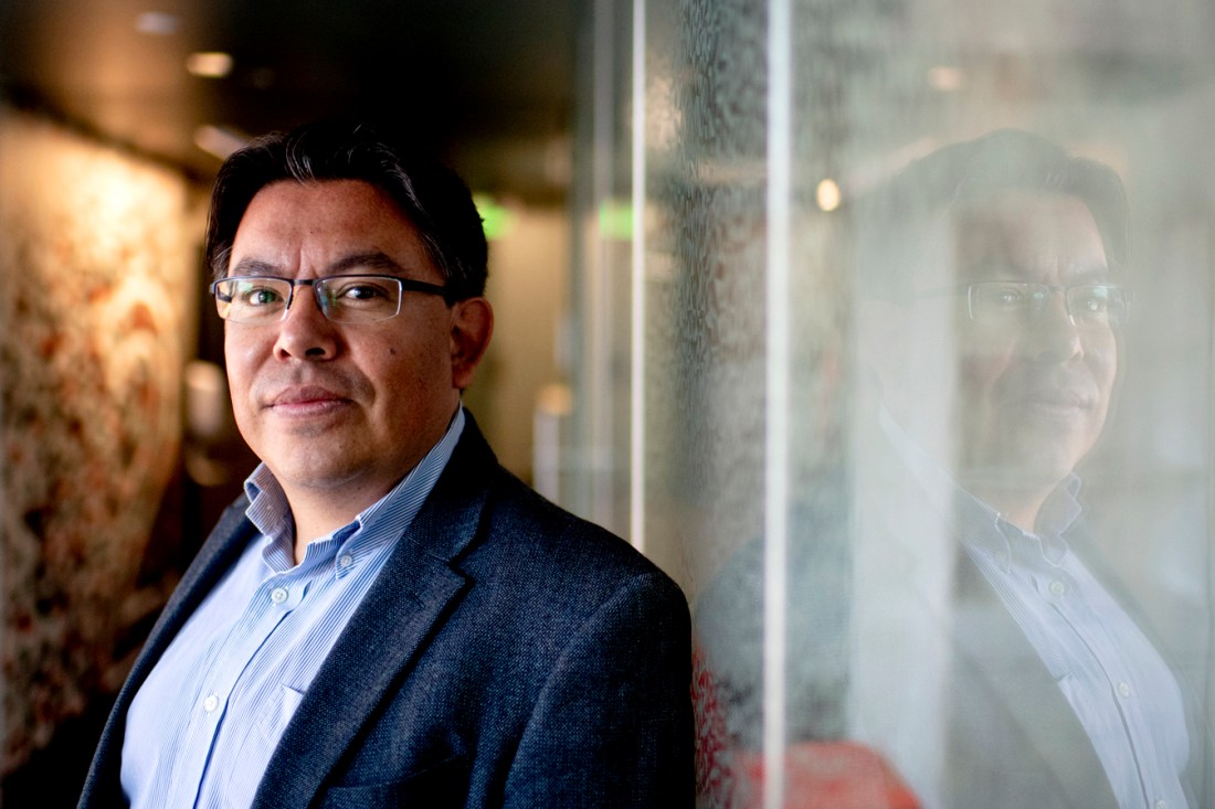 Mauricio Santillana shown standing against a wall.