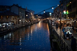 Evening view of an illuminated canal with reflections of lights on the water in Milan.