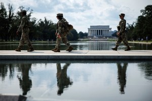 National Guardsmen depicted in front of the National Mall, walking by the Reflecting Pool.