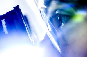 This photo shows a person's eye pressed up against the lens of a camera.