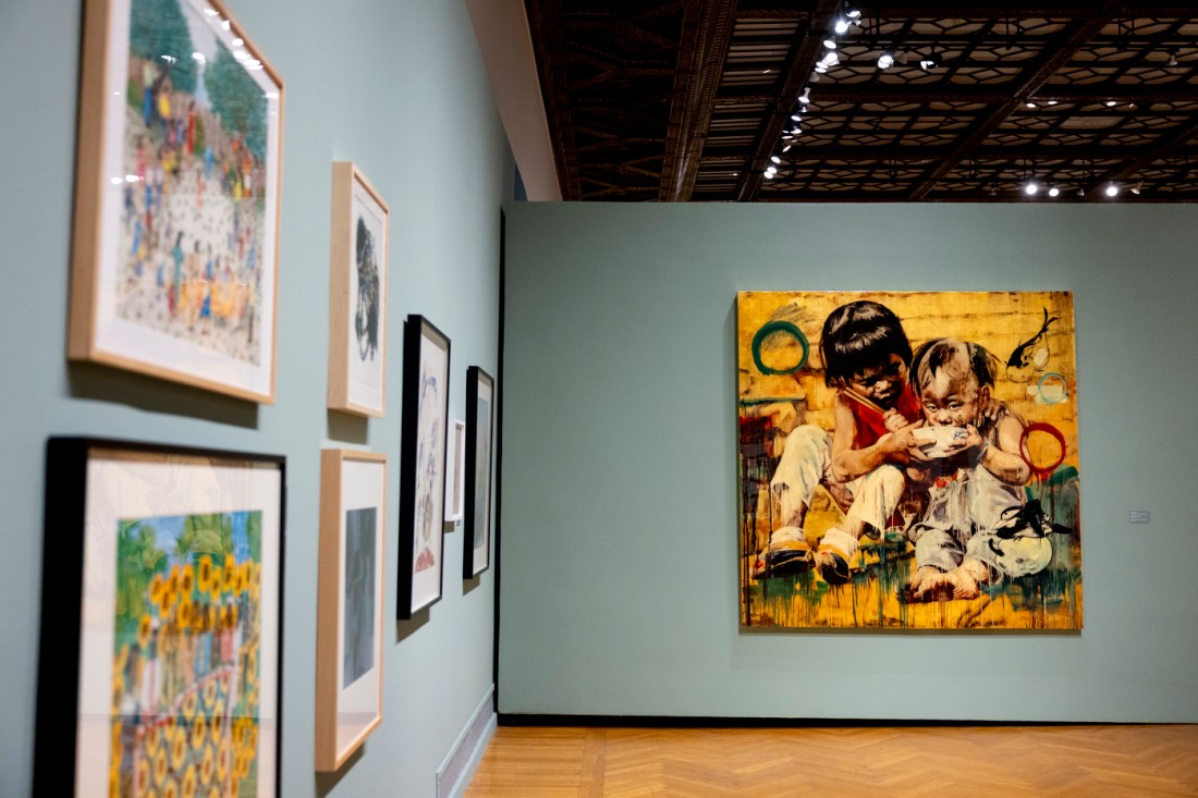 A gallery wall display featuring multiple framed artworks of varying sizes.