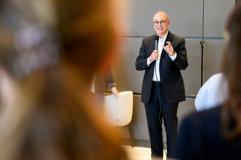 President Aoun speaks into a microphone, welcoming new faculty members to the university.