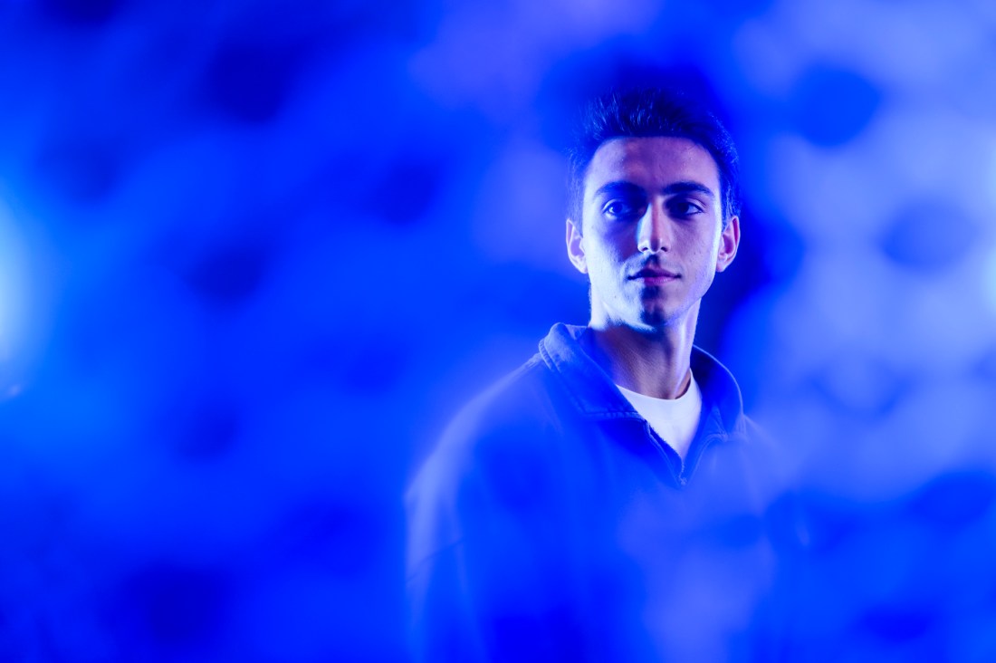 Ruben Noroian, a young man with dark hair, shown standing in a portrait in blue light.