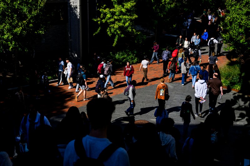 Students walk across the Boston campus on a sunny day.
