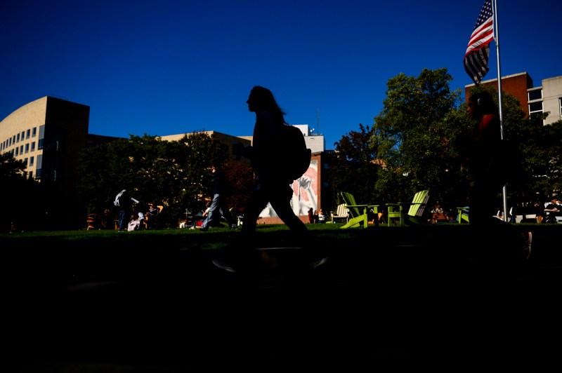 Students walk across the Boston campus on a sunny day.