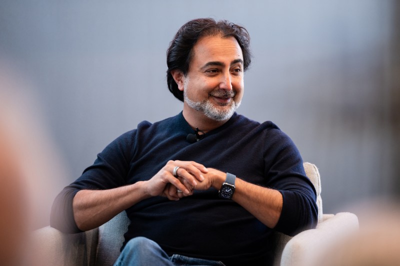Hemant Taneja sits on a chair on a stage.