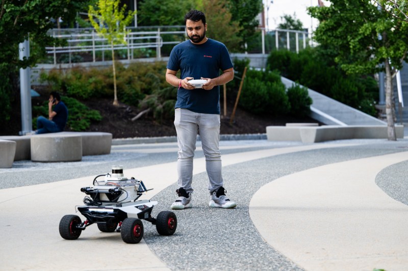 A student tests a robot outside.