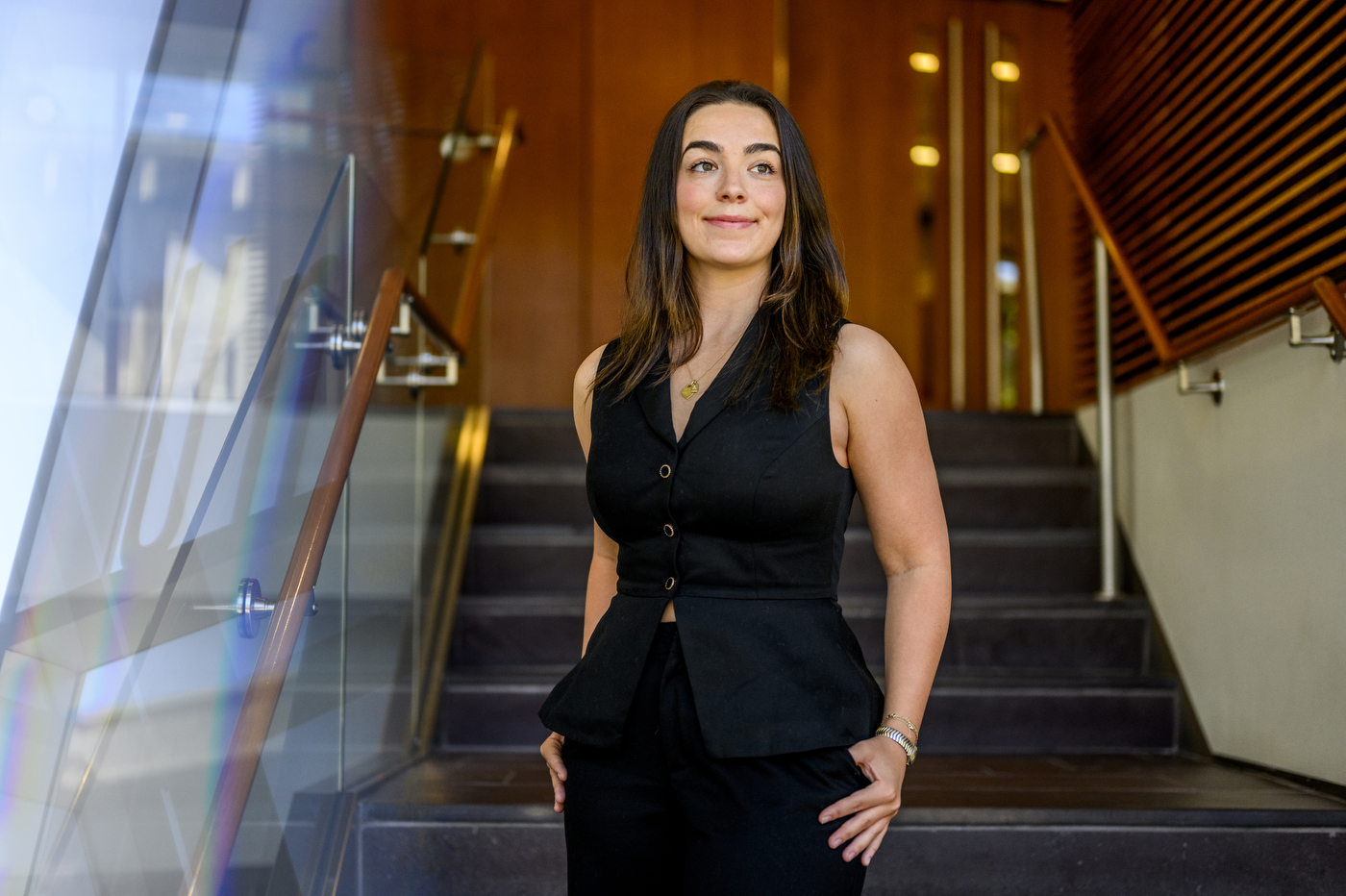 A person poses in front of stairs.