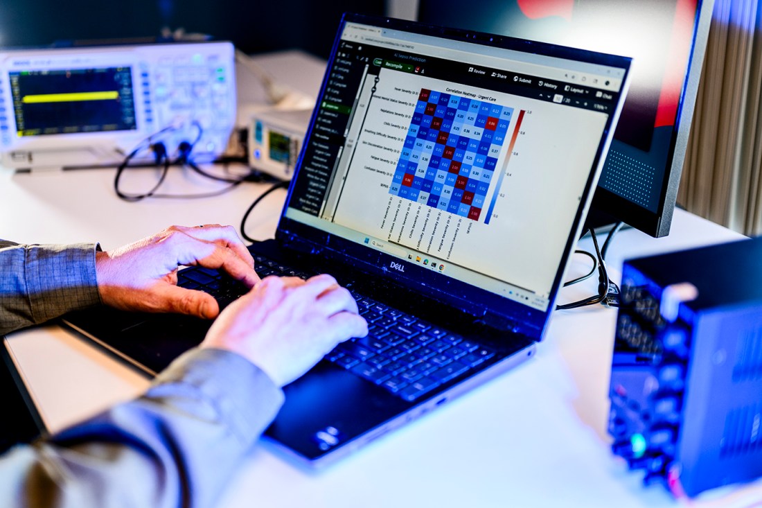 A person typing on a laptop displaying technical, network information.