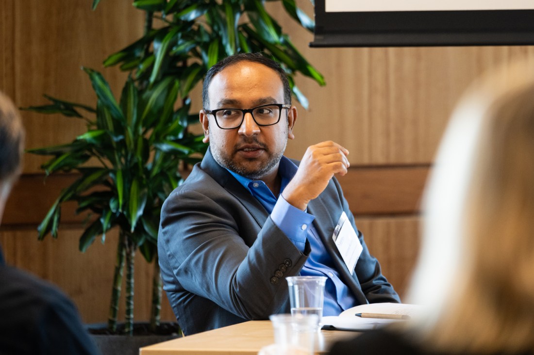 Doctor Abishek Murthy sitting at a table and gesturing toward two colleagues.
