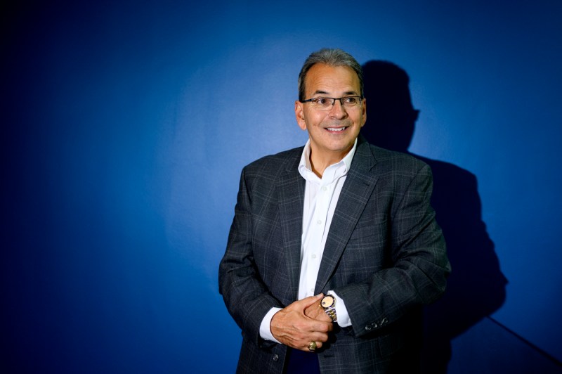 Mike Magliochetti stands in front of a blue backdrop.