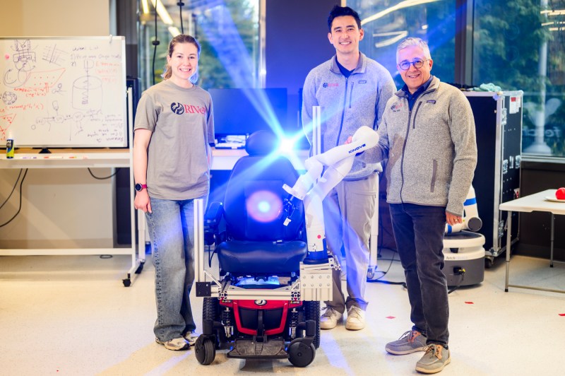 Taskin Padir and two students pose for a photo alongside a robot.