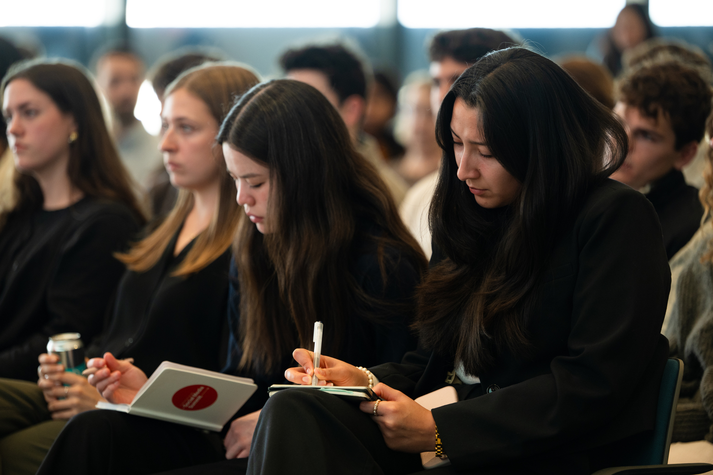 Students seated in an audience take notes and listen attentively during Northeastern University’s President’s Leadership Series event featuring Jeff Weiner, Executive Chairman of LinkedIn.