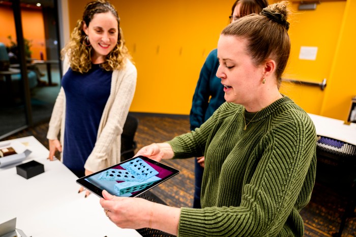 Regina Pagani, Art, Humanities and Experiential Learning Librarian, talks with a colleague.