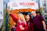 Madison McCall, a Northeastern student, takes a selfie with her parents in front of the &quot;Family &amp; Friends Weekend&quot; welcome sign.