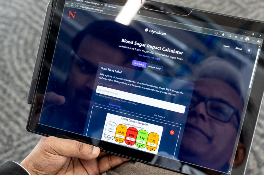 Sushant Dutt holding a tablet showing GlycoScan's blood sugar impact calculator interface with color-coded food rating system from low to high glycemic response.