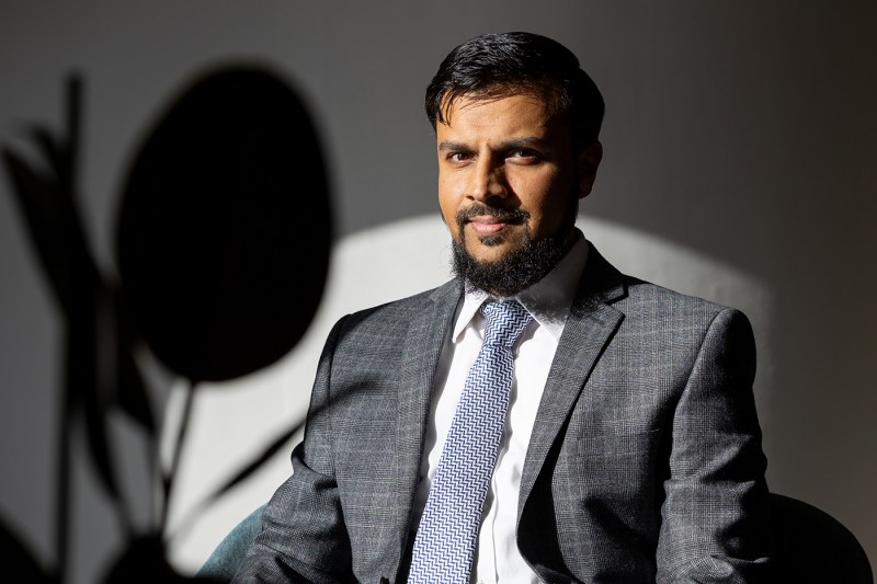 A man in a suite poses for a portrait.