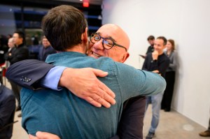 Two men hugging each other at an event.