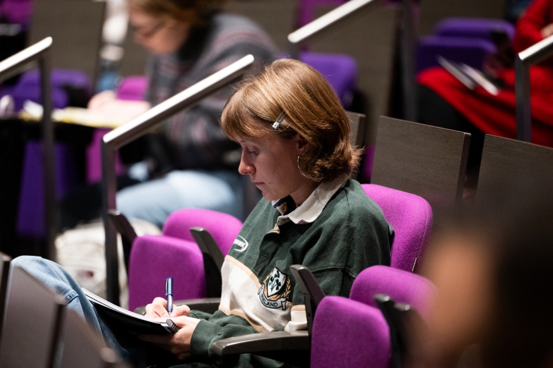 Audience member listens attentively during the Civic Experience: From the Classroom to the Campaign Trail lecture at Northeastern University.