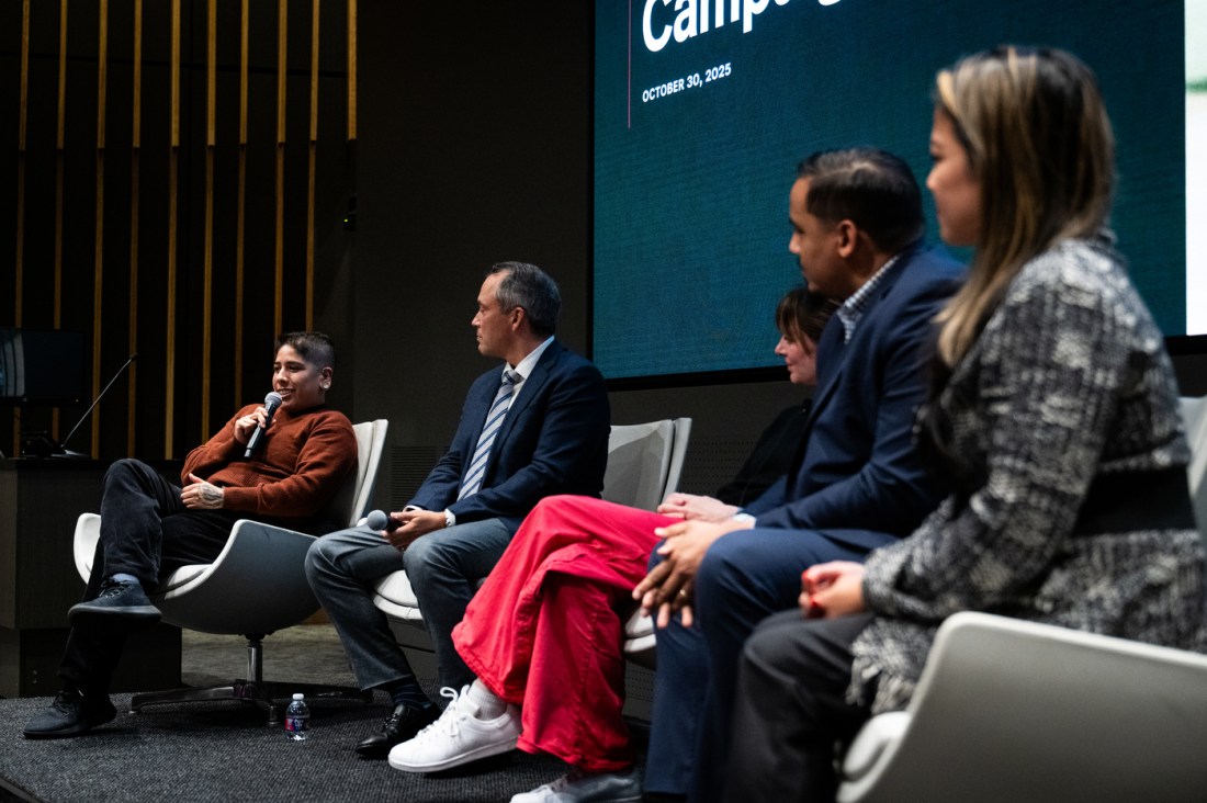 Panelists speak on stage during the Civic Experience event at Northeastern University, with a moderator leading the discussion.