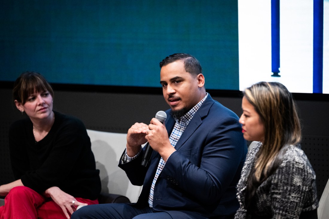 Massachusetts legislator Manny Cruz speaks into a microphone during a panel discussion at the Civic Experience: From the Classroom to the Campaign Trail event.