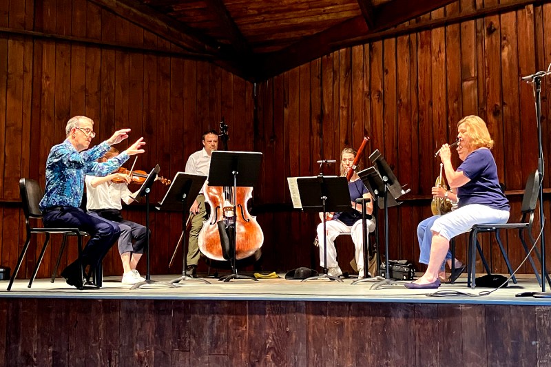 Allen Feinstein conducting a quartet in a wood paneled room.