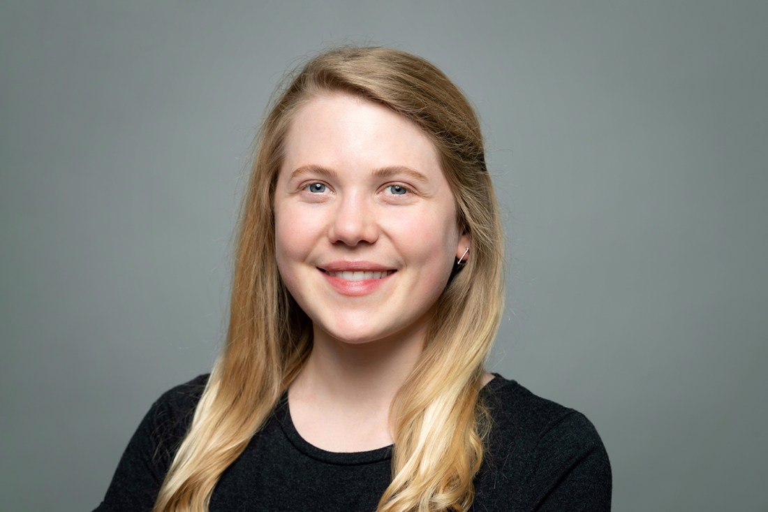 Claire Beskin, a young white woman with blonde hair, smiling against a gray backdrop.